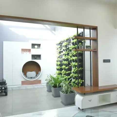 Skylit inner court of a house seen through a teak-framed portal: a full-height pocketed green wall of grey planters beside a wood-and-black-rod open shelf