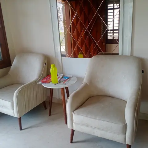 Small seating nook with two cream velvet-look armchairs and a round marble-top side table