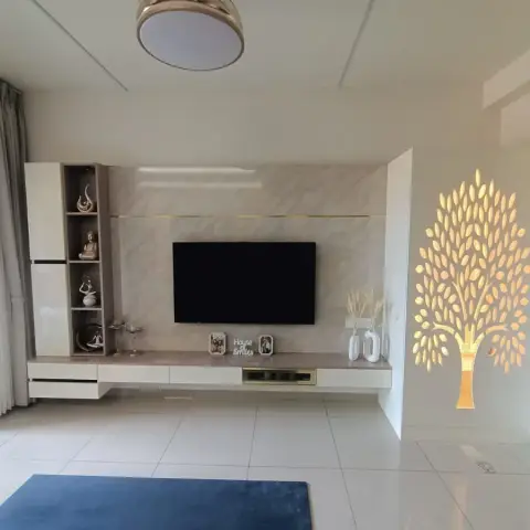 Sparse living room with a floating white TV console under a grey marble-look panel split by a brass inlay line