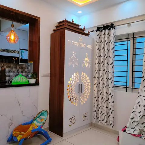 Standalone white and wood pooja cabinet with a temple-style pediment top and backlit jaali-cut doors inscribed with 'Om Gan Ganapataye Namah'
