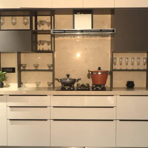 Straight-line kitchen of high-gloss ivory drawer banks under a beige stone counter that turns up as a full-height splashback