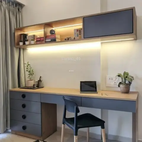 Study corner with a long oak-topped desk over slate-grey drawers with round black knobs, a wall-hung oak shelf box holding books and a grey pinboard shutter