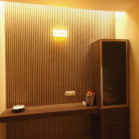 Study nook with a floor-to-ceiling fluted wood panel wall, a wall-mounted study desk lit by a linear sconce