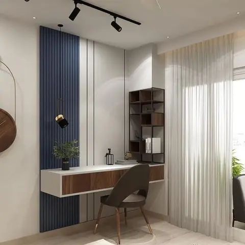 Study nook with a navy fluted-panel accent wall behind a floating white-and-wood desk, an open-cube wall shelf, and a sculptural round wood wall clock.