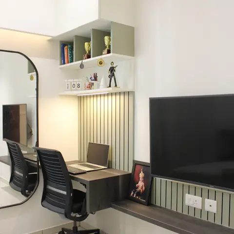 Study nook with a wall-mounted desk, fluted sage-green panelling, and open shelving displaying trophies and medals, beside a mounted TV in a teen's bedroom.