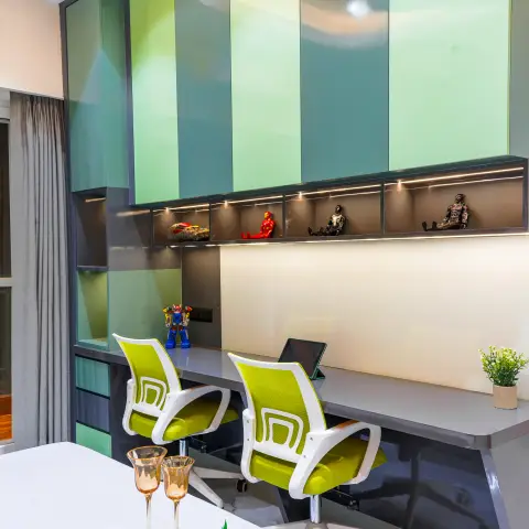 Study nook with glossy green-toned loft cabinets, a lit display shelf showcasing superhero action figures