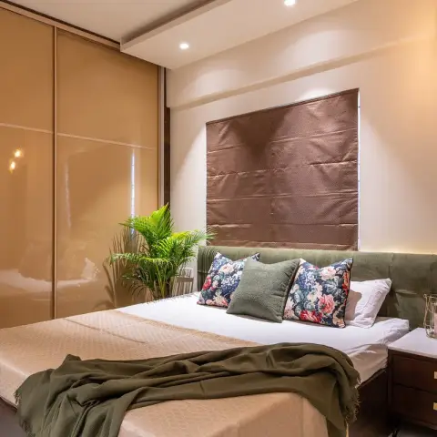 Styled bedroom with an olive velvet headboard running on as a low wall panel, a quilted brown leather panel floating above it