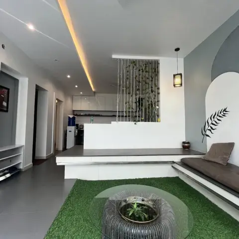 Sunken living area with a built-in bench under a painted grey-and-white double-arch mural carrying a black fern motif