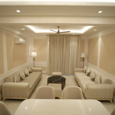 Symmetric living room with cream channel-tufted sofas facing a round black coffee table