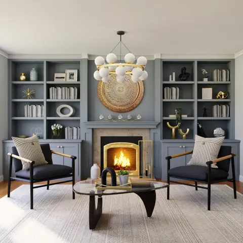 Symmetrical fireplace wall of slate-blue built-in bookcases with a gold filigree mandala platter above the marble mantel