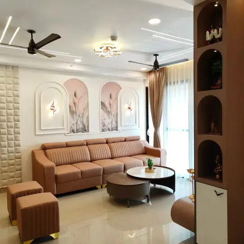 Tan channel-tufted leather sofa under twin arched mouldings framing blush botanical panels