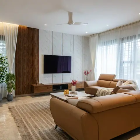 Tan leather recliner sofas face a marble-slab TV wall scored with vertical groove lines