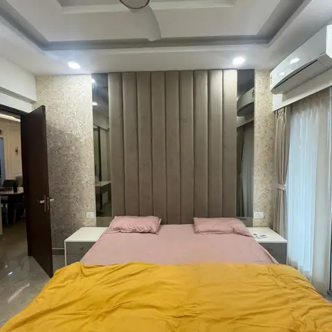 Taupe channelled headboard panel running floor to ceiling between mirror strips and geometric wallpaper