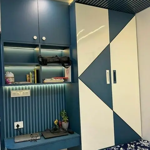 Teal and white diamond colour-blocked wardrobe beside a built-in study nook with under-shelf lighting and a black slatted ceiling.