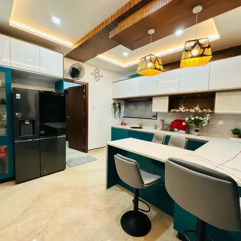 Teal gloss base units run into a peninsula breakfast counter with four grey bar stools, white gloss overheads above a warm-grey mosaic dado
