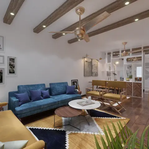 Teal three-seater and mustard daybed under faux-wood ceiling beams with recessed spots