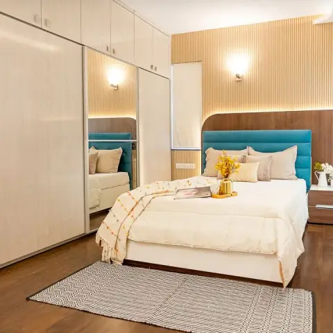 Teal velvet channel-tufted headboard on a curved walnut back panel, backlit fluted wall