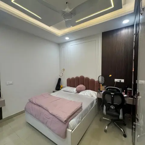 Teen's bedroom with a scalloped terracotta velvet headboard bed, a fluted dark wood panel accent wall, a built-in study desk with office chair