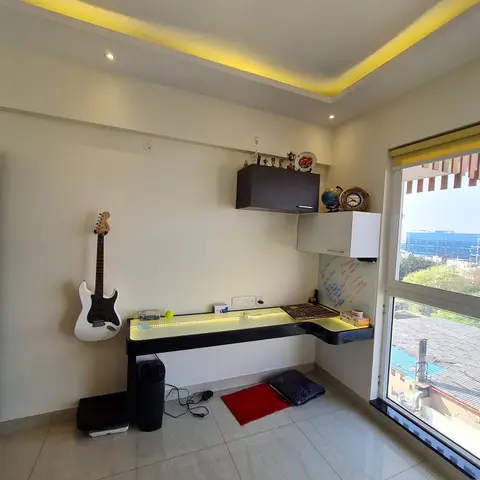 Teen's study nook with an LED-edge-lit desk, wall-mounted trophy shelf and a guitar hung on the wall.