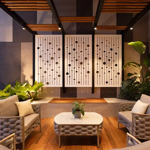 Terrace lounge with woven rope armchairs around a marble-top coffee table, a wood pergola overhead