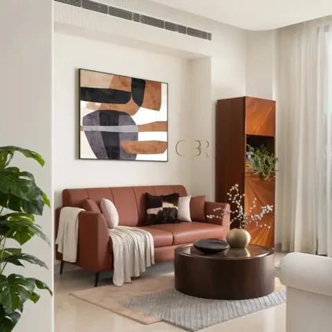 Terracotta leather sofa with cream throw beside a round dark-wood coffee table and a tall walnut bar cabinet with a large abstract painting above