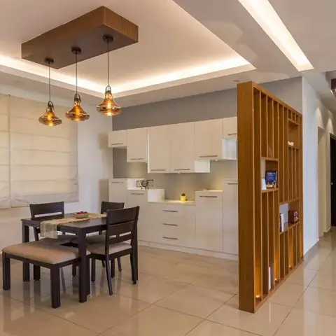 Three amber glass pendants drop from a solid wood ceiling raft over a dark-wood dining table with a bench