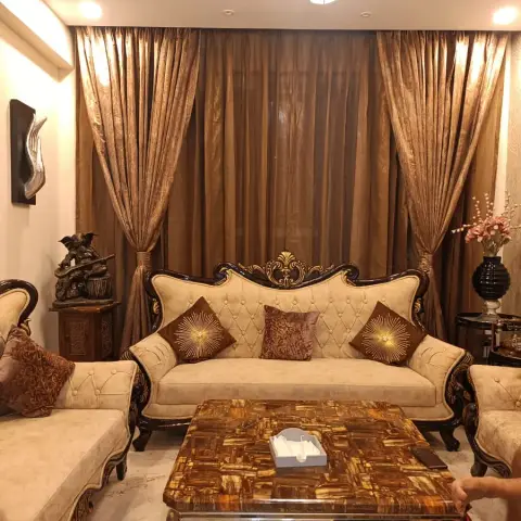 Traditional living room with a carved dark-wood and gold-trim tufted sofa set, a tiger's-eye mosaic coffee table
