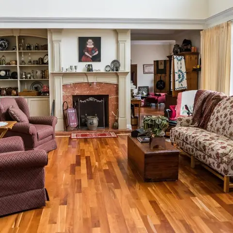 Traditional living room with a marble fireplace mantel, floral chintz-upholstered sofa and matching armchairs