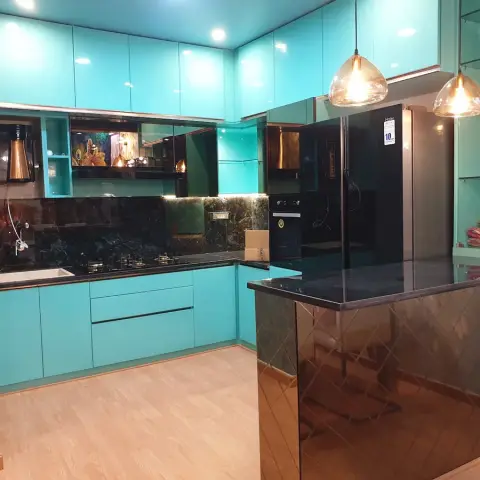Turquoise high-gloss modular kitchen with a black granite counter, book-matched dark green marble dado