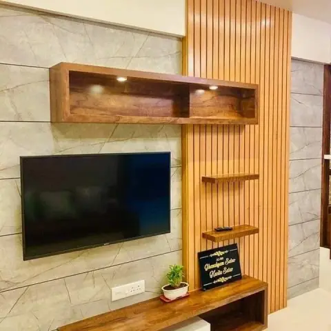 TV feature wall combining grey marble-look cladding with a vertical fluted wood panel, a floating wood media console, and a backlit display shelf above.