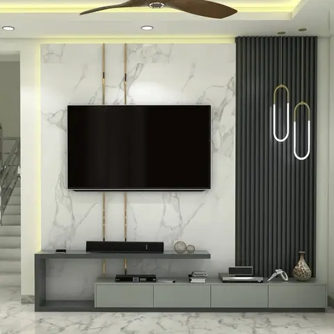 TV feature wall combining white-veined marble with a dark grey fluted panel, brass inlay strips flanking the television, and two paperclip-style pendant lights.