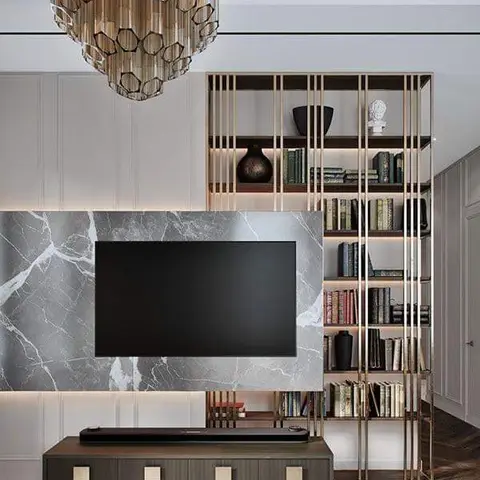 TV feature wall in book-matched grey marble beneath a hexagonal glass-tube chandelier