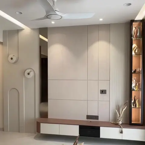 TV feature wall in ribbed stone-effect cladding beside a backlit display niche styled with a curated row of figurines