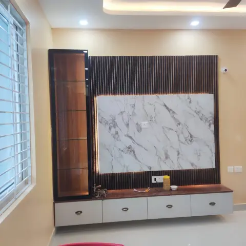 TV feature wall of walnut fluted panelling framing a white marble-look slab, with a glass-shelved display tower on the left and a wall-hung white drawer