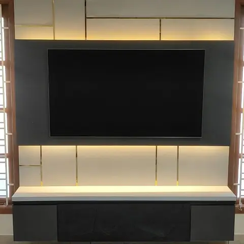 TV feature wall with a backlit grey-and-white geometric panel grid framed in brass inlay lines, and a floating dark wood media console below.