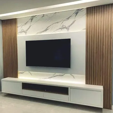 TV feature wall with a backlit marble slab panel flanked by vertical fluted wood battens above a floating white TV console