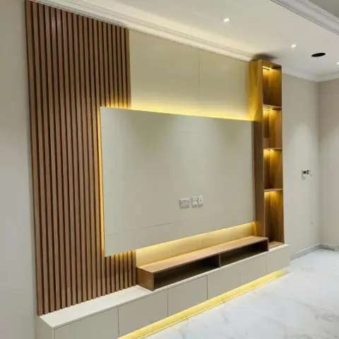 TV feature wall with a fluted wood-slat border and a backlit floating console beside an internally lit open shelving column.