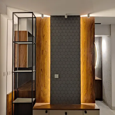 TV feature wall with book-matched wood-veneer pillars flanking a charcoal hexagon-tiled backsplash