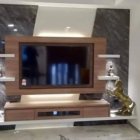 TV feature wall with dark grey stone cladding, a wood-framed floating TV panel, white display shelves with statuettes, and a gold horse figurine on the floor.