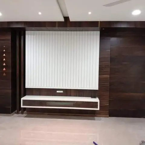 TV feature wall with dark walnut-veneer panelling either side of a white fluted centre panel and a floating white console