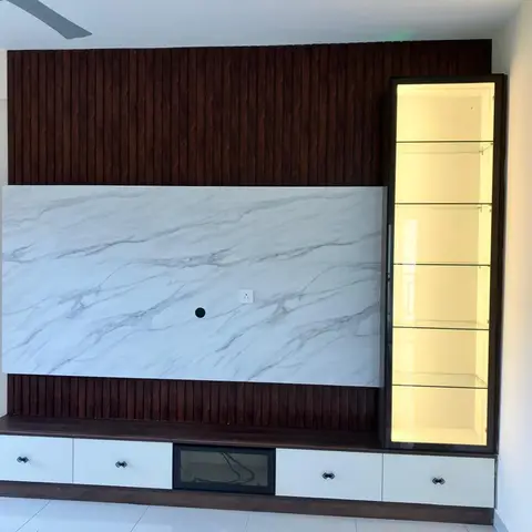 TV feature wall with fluted dark-wood panelling and a bookmatched marble panel, flanked by a backlit glass display cabinet