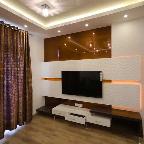 TV feature wall with textured 3D white wall panels edge-lit in amber LED, a glossy bronze mirrored panel above, and a floating white TV console.