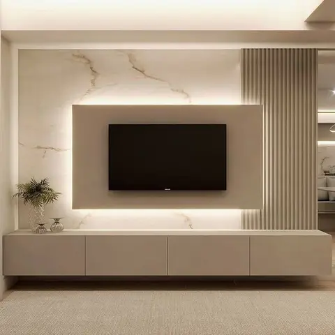 TV wall clad in backlit gold-veined marble flanked by a fluted wood panel, above a long floating cream console styled with a vase.
