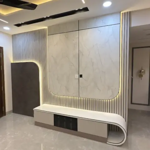 TV wall of a handover-ready flat: a rounded-corner marble-look slab outlined in concealed LED