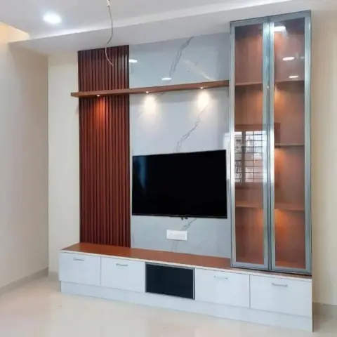 TV wall pairing a fluted wood accent panel with a marble-effect backdrop, alongside a glass-front backlit display cabinet and a white floating console.