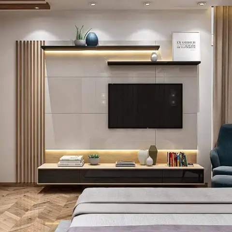 TV wall seen over the foot of a grey-and-lilac bed: two staggered black floating shelves above a gloss panel