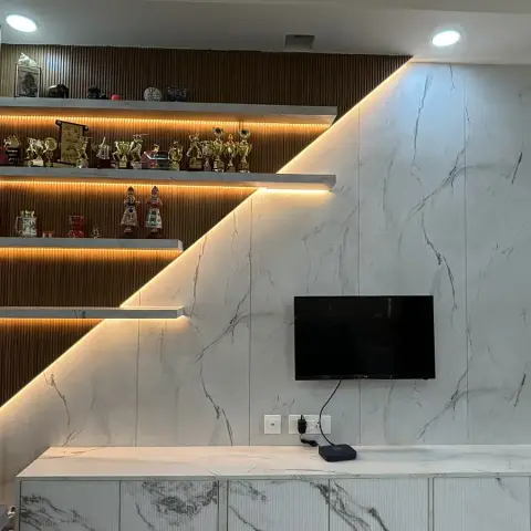 TV wall split on a diagonal, white marble-look slab tile meeting a fluted wood back