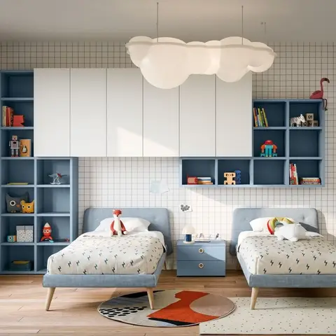 Twin-bed kids' room with matching blue upholstered beds, blue-and-white cubby shelving styled with books and toys