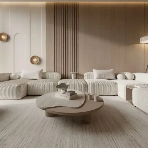 Two cream corduroy modular sofas face each other over a pair of overlapping organic-shaped stone and wood low tables