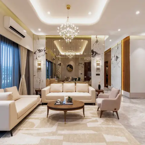 Two cream sofas and a blush armchair around a round wood coffee table, beneath a tiered crystal chandelier and backed by a book-matched marble feature wall